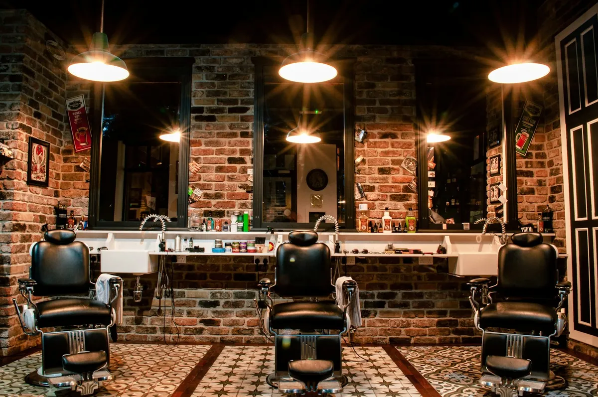 Ghế barber bằng da bên bức tường gạch